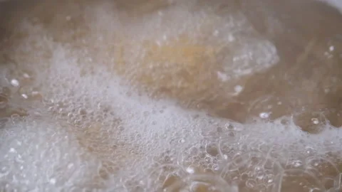 Cooking pasta inside boiling water, iron cast pot, close up Stock Footage 204999537