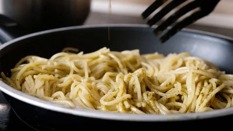 Cooking pasta with pesto, adding basil pesto Stock Footage 118073823