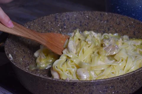 Cooking pasta in  saucepan on the stove in  kitchen. spaghetti is boiled Stock Photos