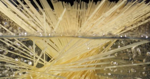 Cooking pasta spaghetti. Chef throwing raw spaghetti into boiling water in pot Stock Footage 251858489