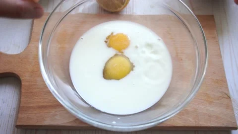 Cooking pastry process at home. Add sugar in a bowl with milk and eggs and mix  Stock Footage 153104792