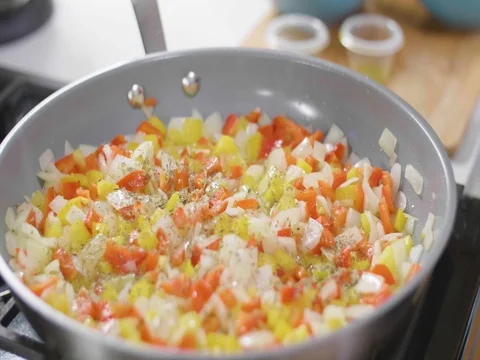 Cooking peppers in a frying pan Stock Footage