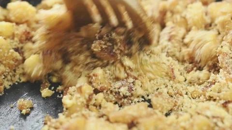 Cooking a pieces apple with bread crumbs and walnuts in a frying pan. Stock Footage 159908635