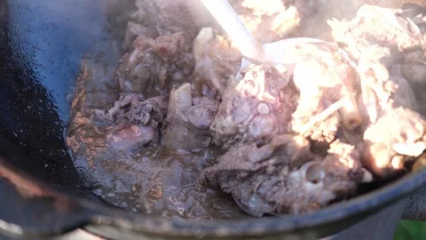 Cooking pilaf in a large cauldron in nature, outdoors. National rice dish. Stock Footage 247709154