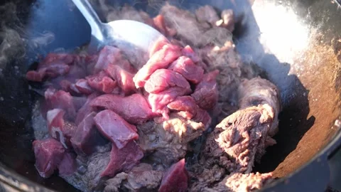 Cooking pilaf in a large cauldron in nature, outdoors. National rice dish. Stock Footage 247712976