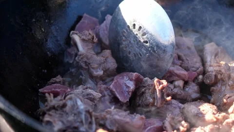Cooking pilaf in a large cauldron in nature, outdoors. National rice dish. Stock Footage 249497537