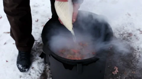 Cooking of pilaff. A man pouring the rice to pieces of braised lamb in cauldron Vídeos de archivo 63662089