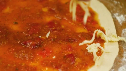 Cooking pizza. Chef put cheese and basil on the base of the pizza greased with Video stock 104780540