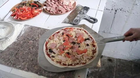 Cooking pizza. The final stage - the pizza is sent to be baked in the oven Stock Footage 77201332