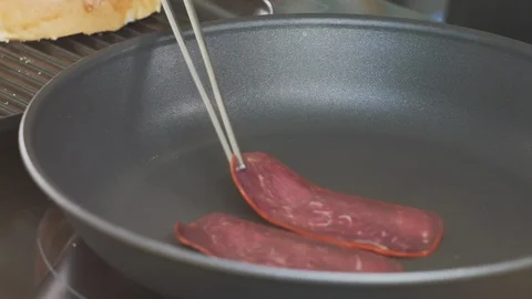 Cooking: Placing Slices of Dark Red Bacon Meat Cuts In Frying Pan With Tweezers 스톡 동영상 118600925