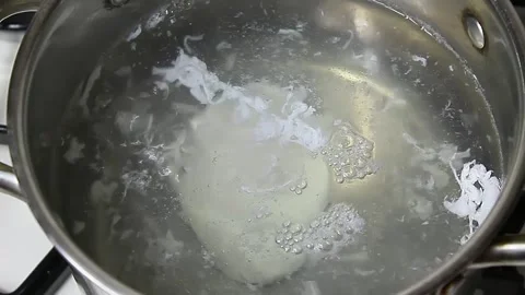 Cooking poached egg in soucepan Stock Footage 150918819