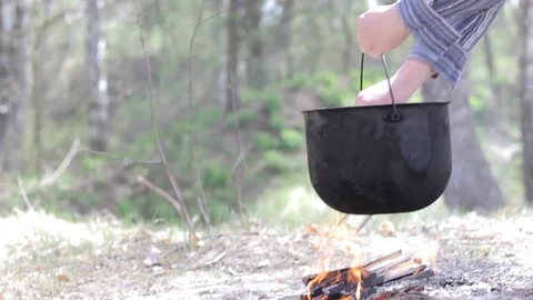 Cooking in a pot over campfire Stock Footage 88808015