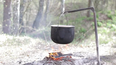 Cooking in a pot over campfire Stock Footage 88808740