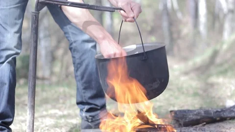 Cooking in a pot over campfire Video stock 88809576