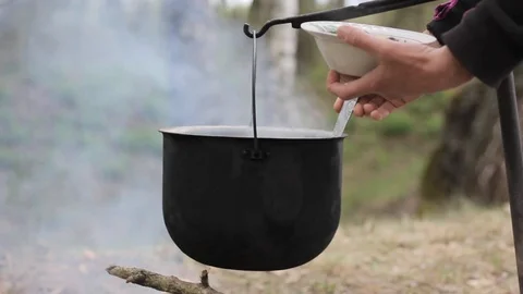 Cooking in a pot over campfire Stock Footage 88810323