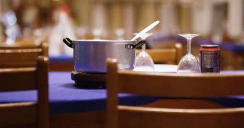 Cooking pot placed on table with purple tablecloth and glasses Stock Footage 156283090