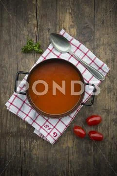 Cooking Pot Of Tomato Soup On Kitchen Towel And Wooden Table