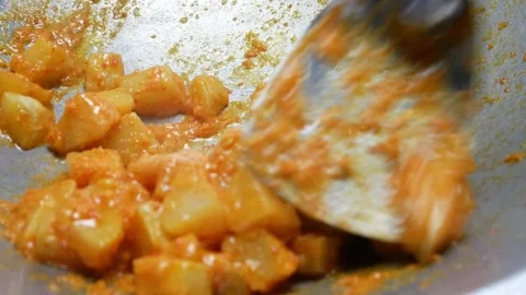 Cooking potatoes cut into small pieces with balado seasoning in a frying pan Stock Footage 304729352
