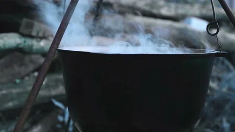 Cooking potion in a pot on a fire in the forest halloween preparation. Stock Footage 159877970
