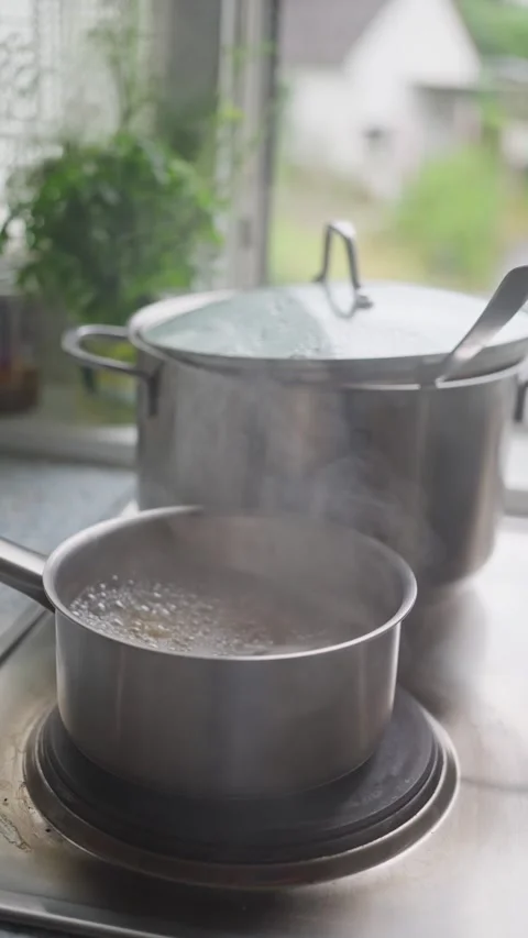 Cooking Pots Placed on a Stove with Steaming Water Boiling Inside for Delicious Stock Footage 308461848