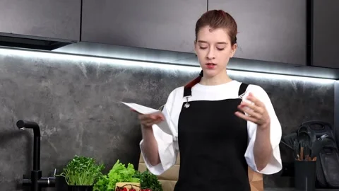 Cooking preparations in a modern kitchen with fresh ingredients and a recipe Stock-Footage 296317686