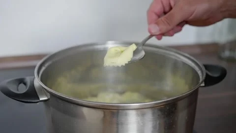 Cooking Process Adding Butter to Pot for Creating a Delicious and Flavorful Dish Stock Footage 312327216