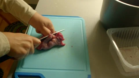 Cooking Process Cutting Meat on a Blue Cutting Board for Meal Prep Stock Footage 318926435