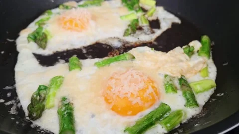 Cooking process of eggs and asparagus in a frying pan Stock Footage 333822045