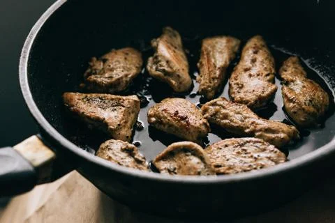 Cooking process. Fried chicken steak in a frying pan. fatty junk food. Stock Photos