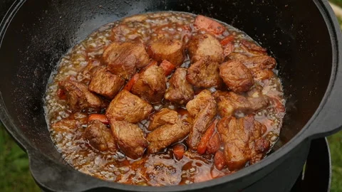 Cooking process, frying pork meat on open fire. Close up, slow motion Stock Footage 131648004