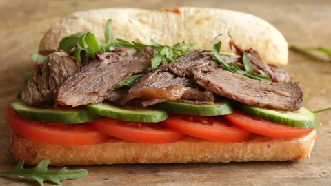 Cooking process making roast beef sandwich with tomato cucumber arugula Stock Footage 90063057