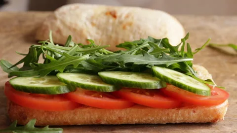 Cooking process making roast beef sandwich with tomato cucumber arugula Stock Footage 90063066