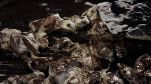 Cooking process of meat pieces being sauteed in a frying pan with a spatula Stock Footage 335234735