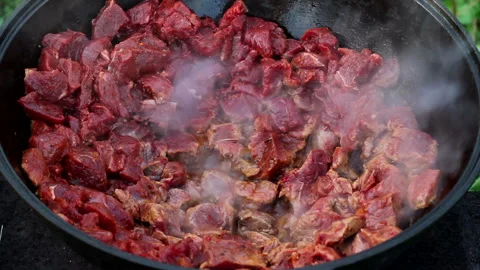 Cooking process of an oriental dish. red meat boils and stews in oil Stock Footage 122567057