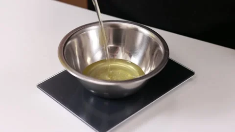 Cooking process. Professional chef is weighing egg whites in metal bowl Stock Footage 220040052