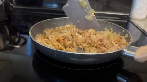 Cooking process roast meat in a frying pan on an electric stove Stock Footage 241029379