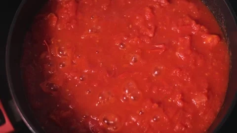 The cooking process shows a pot filled with simmering tomato sauce on a stovetop 库存影片 344667442