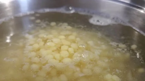 Cooking process of small round pasta boiling in a stainless steel pot Stock Footage 337965206