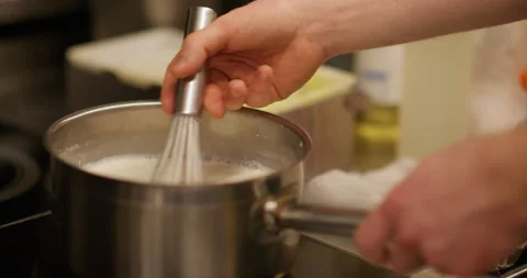 Cooking process stirring whisk saucepan milk chef Stock Footage 323950768