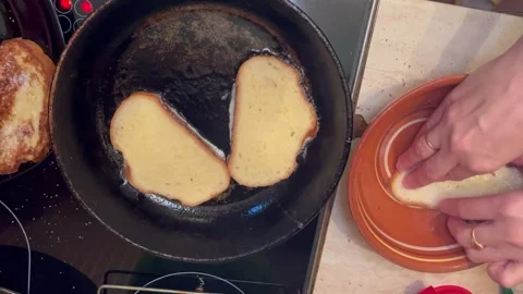Cooking process of toasting bread in a skillet, with hands placing slices into a Stock Footage 320874174