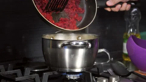 The cooking process, vegetables in tomato sauce from the pan are poured into the Stock Footage 213618717