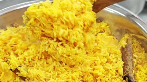 Cooking process of yellow spiced rice or Biryani with a wooden paddle. Vídeo Stock 344035912