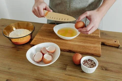 Cooking in progress. Eggs, flour, salt on the table, cutting board and knif.. Stock Photos