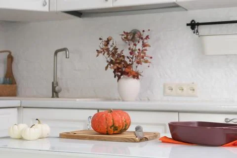 Cooking pumpkin for baking in ceramic dish on wooden board on wooden table in Stock Photos
