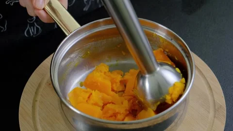 Cooking Pumpkin Soup with Immersion Blender in Kitchen Video stock 341434831