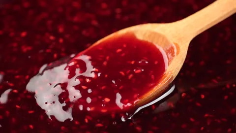 Cooking raspberry jam, close up. Stirring raspberry jam with wooden spoon Stock Footage 252265181