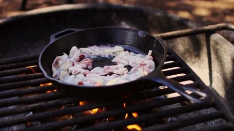 Cooking raw bacon meat with hot cast iron pan. a frying pan with bacon and oil. 스톡 동영상 334642983