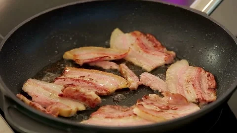 Cooking raw bacon meat with hot cast iron pan. a frying pan with bacon and oil. 스톡 동영상 334643098