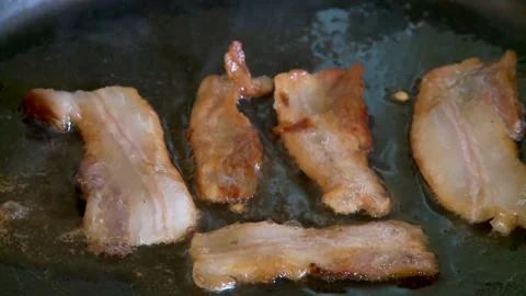 Cooking raw bacon meat with hot cast iron pan. a frying pan with bacon and oil. 스톡 동영상 334643208