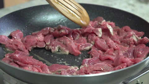 Cooking raw beef in a black pan, close up Stock Footage 154216049